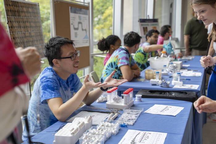 Louis Li of the Brady lab, helps explain how microbes from dirt can inspire new medicines, and entices visitors to make keychains mapping promising molecules.